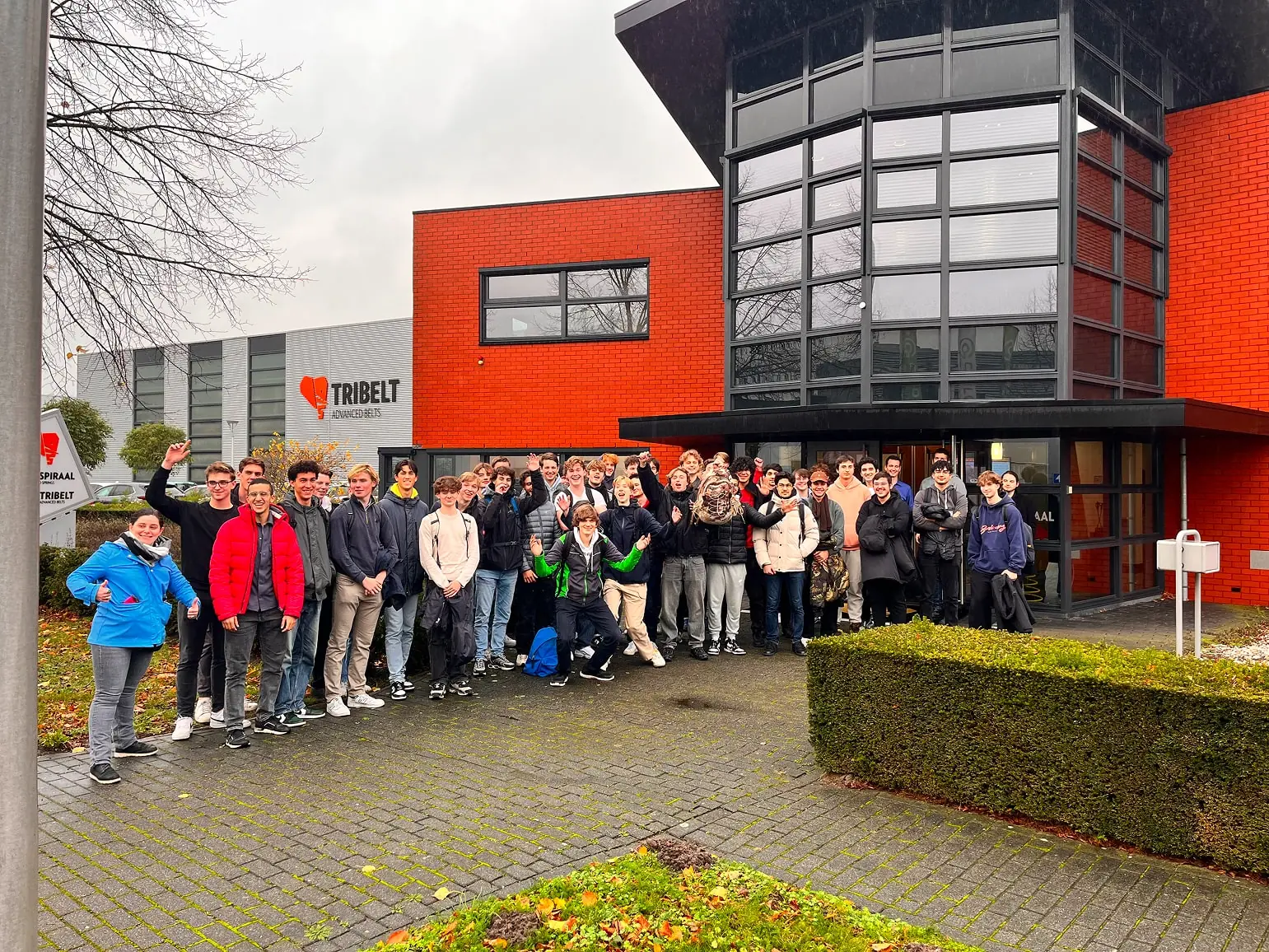 Groep studenten werktuigbouwkunde voor het oranje bedrijfspand van De Spiraal en Tribelt
